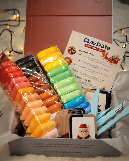 ClayDate kit with colorful clay bars and tools on a gray surface with Christmas lights in the background
