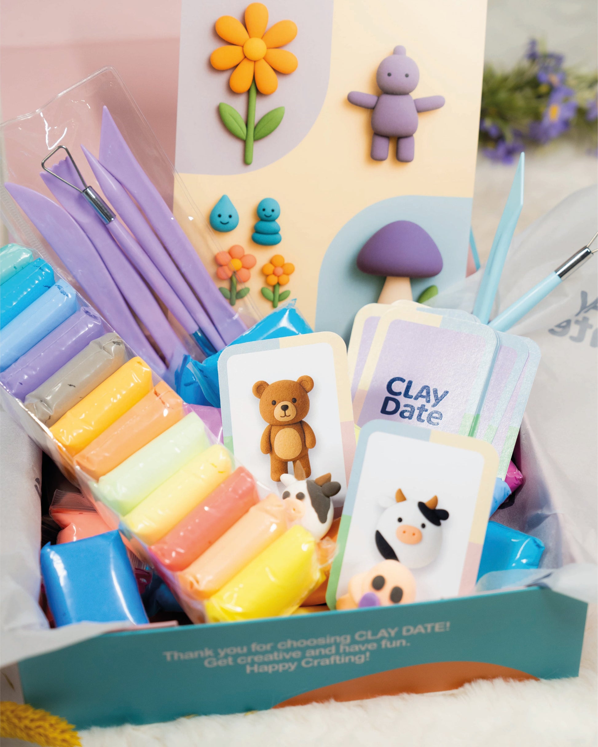 Colorful clay kit with tools and cards on a white background