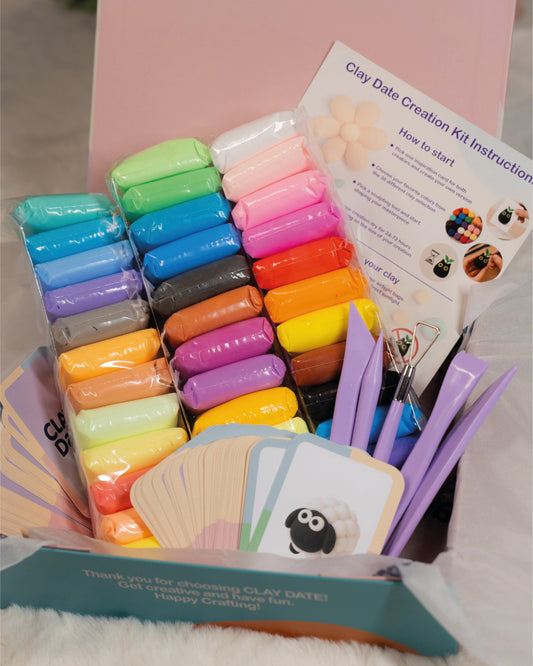 Clay date creation kit with colorful clay blocks, tools, and instructions on a pink background.