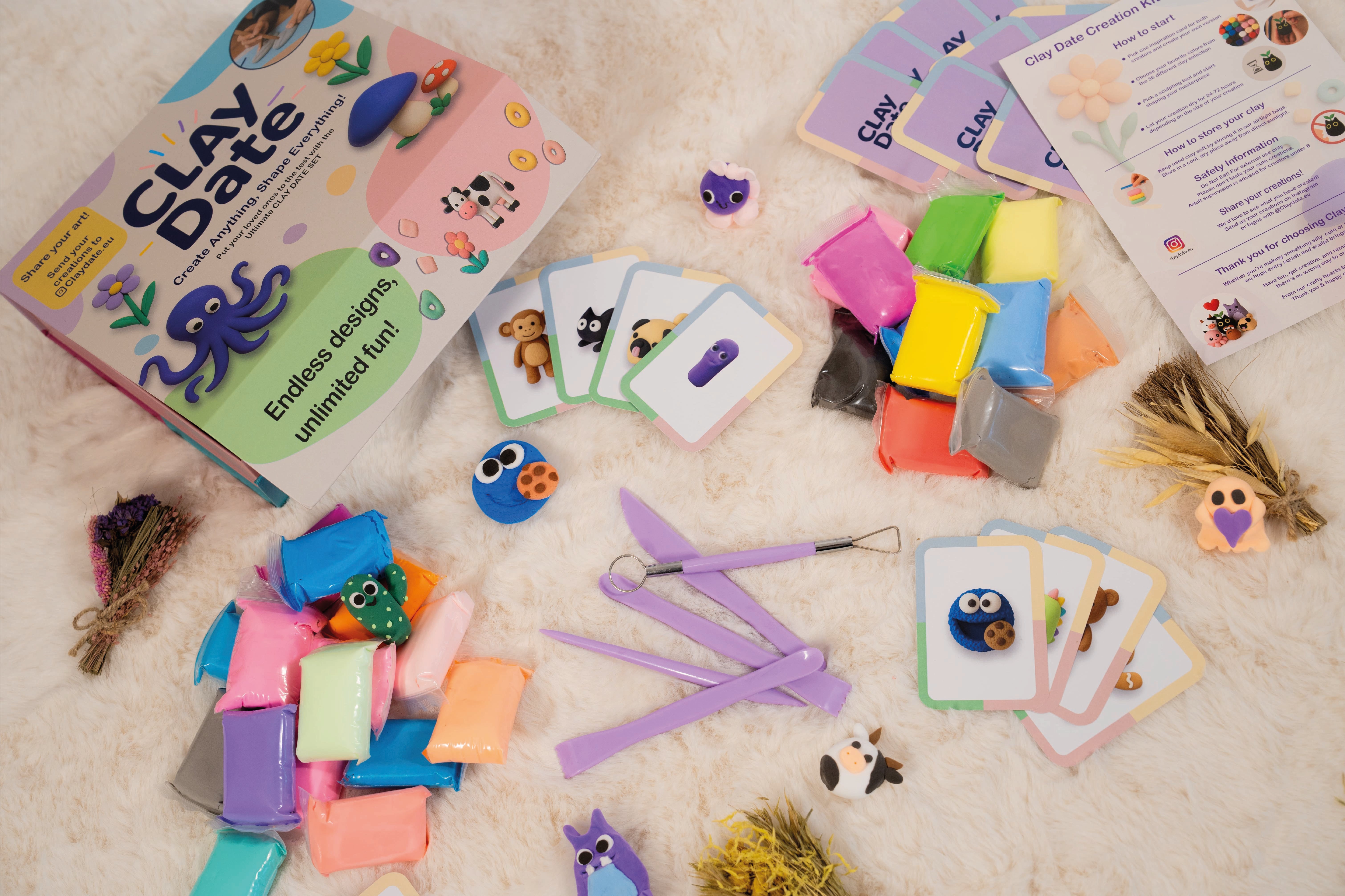Colorful clay modeling kit with tools and cards on a soft surface