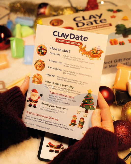 Person holding a 'Clay Date' Christmas edition instruction manual with festive decorations in the background.