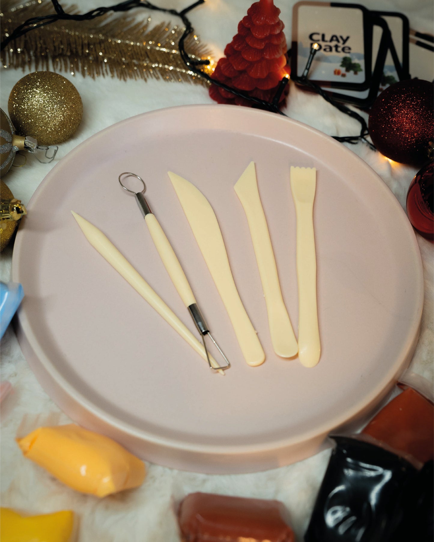 Decorative items including a plate with tools, Christmas ornaments, and cards on a textured surface.