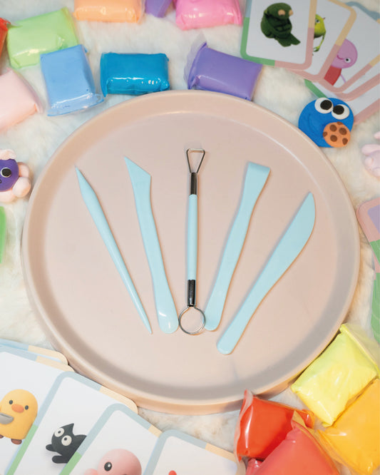 Colorful playdough blocks and tools on a pink tray with animal cards in the background.