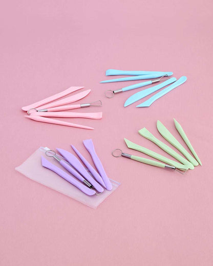 A set of pastel-colored sculpting tools arranged on a solid pink background.