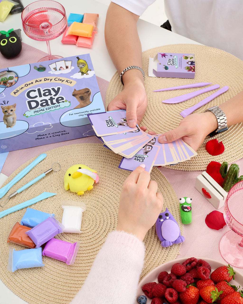 Hand holding a meme prompt card next to a clay creation from the Clay Date™ Meme Kit