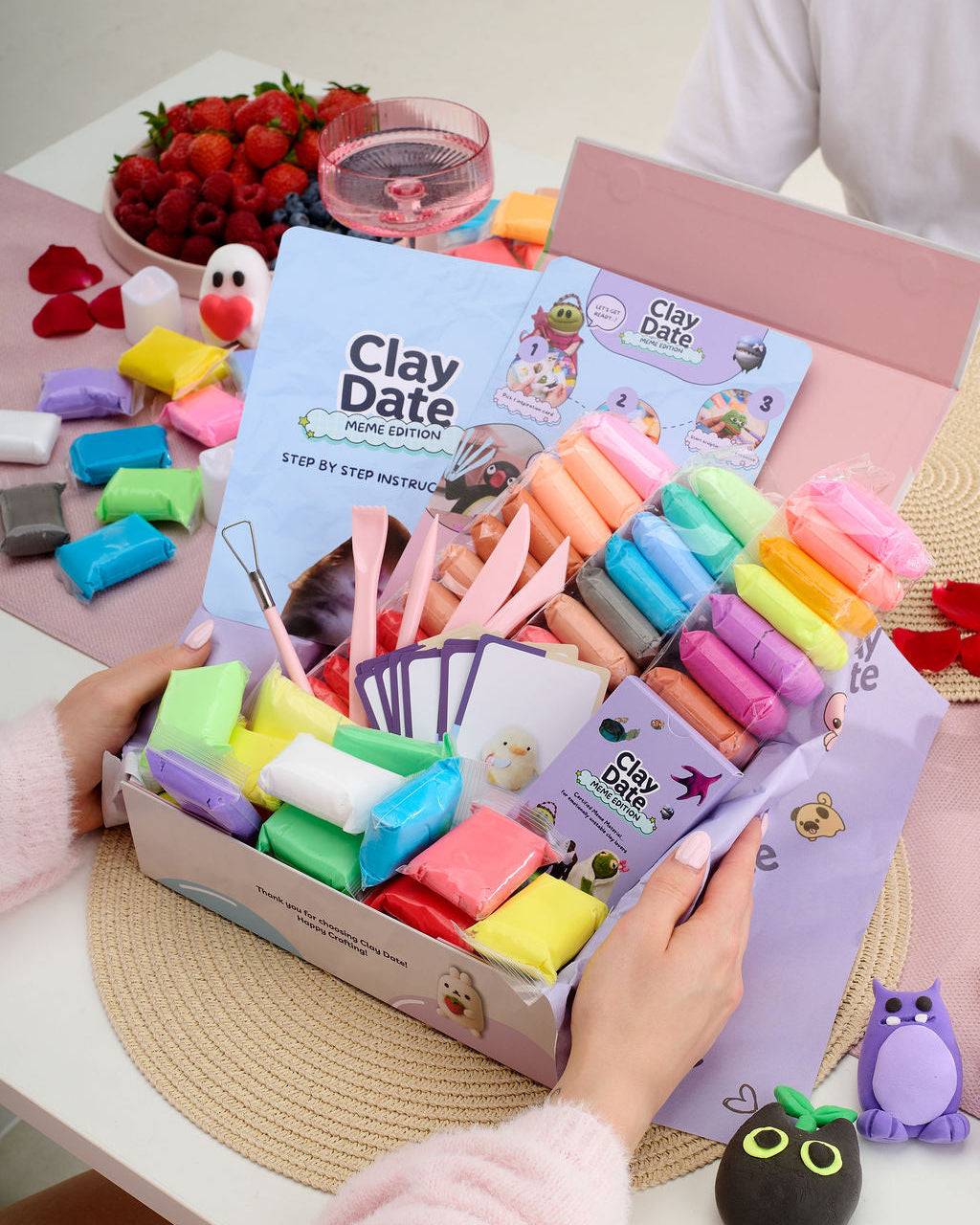 Meme prompt cards and clay creations spread out during a Clay Date™ Meme Kit session