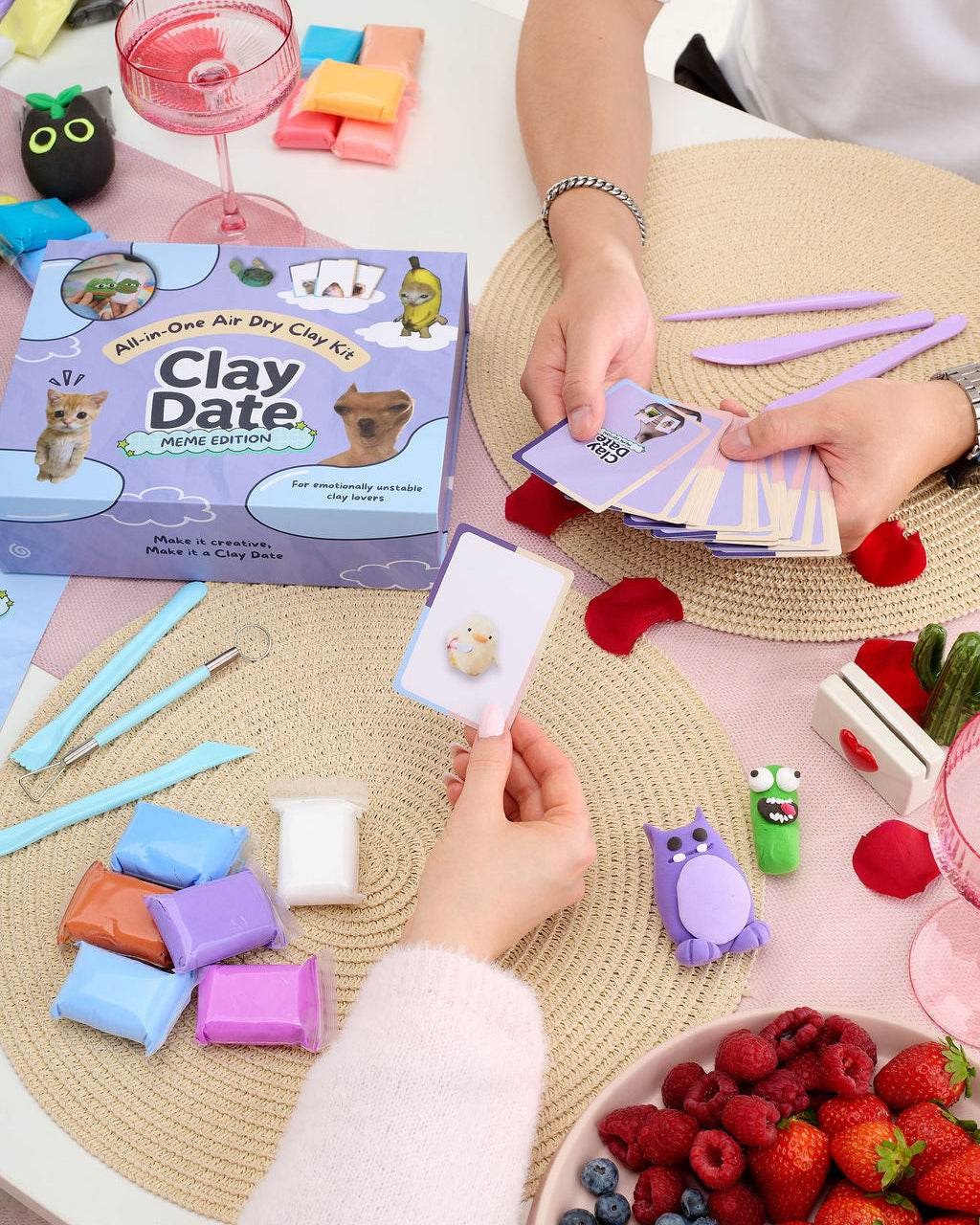 Multiple clay creations and meme cards from the Clay Date™ Meme Kit arranged on a table