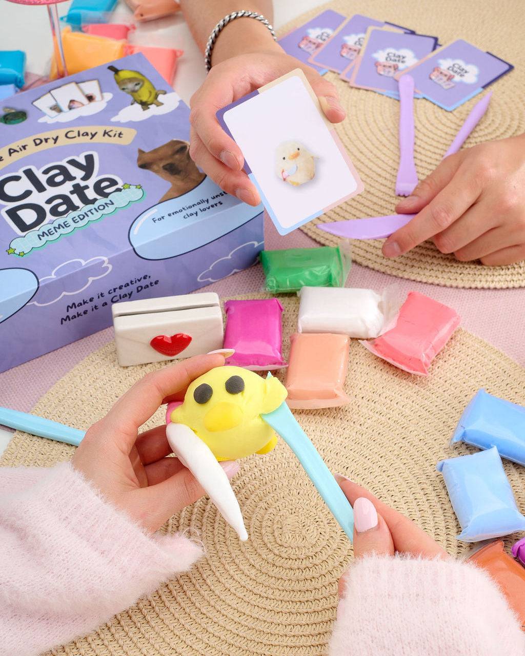 Person showing finished clay creations from a Clay Date™ Meme Kit session