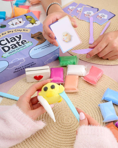 Person showing finished clay creations from a Clay Date™ Meme Kit session