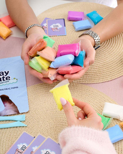 Hand holding up a completed clay creation made with the Clay Date™ Meme Kit