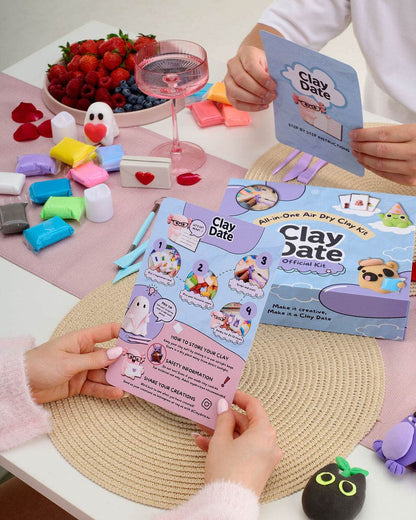 A person holds a 'Clay Date' mini-arts as dry clay kit instruction card over a table with the product box.