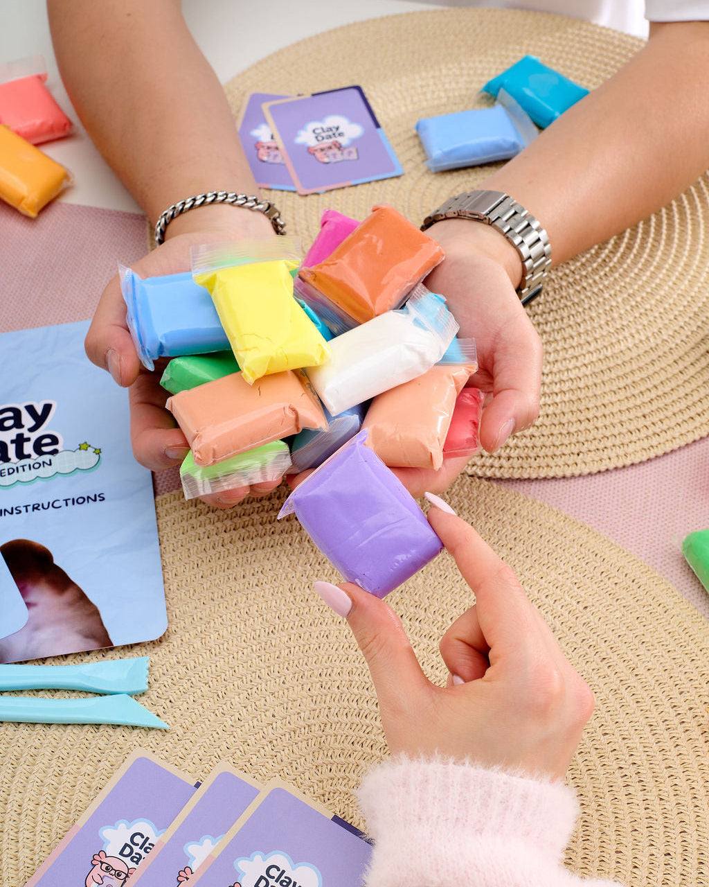 Hand using a sculpting tool from the Clay Date New Official Kit to shape a clay creation